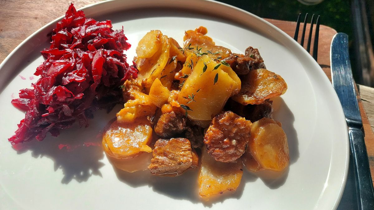 Beef hot pot with sliced potatoes, chorizo and braised red cabbage