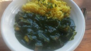 Homemade saag paneer with spinach and paneer served with yellow rice