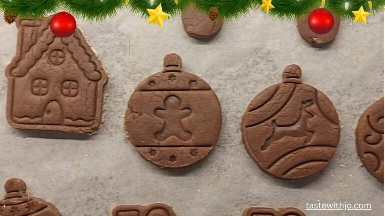 Traditional Polish gingerbread cookies (pierniczki) shaped like Christmas ornaments and a gingerbread house, decorated with festive greenery.